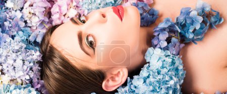Photo for Makeup cosmetics and skincare. Nature beauty. Woman lying on flowers. Unity with nature. Blossom. Girl with hydrangea flowers. Banner spring design, advertising for website header - Royalty Free Image