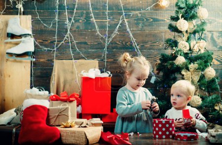 Photo for Happy child with a Christmas present on wooden background. Christmas story concept. Cute little kids celebrating Christmas. Christmas kids - happiness concept. kiddy - Royalty Free Image