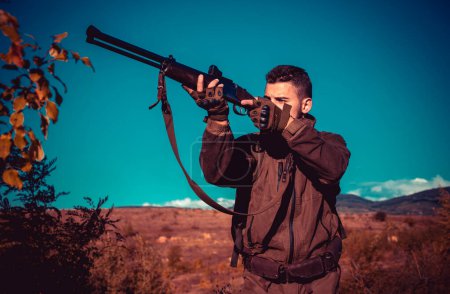 Photo for Hunter with shotgun gun on hunt. Calibers of hunting rifles. Hunter with Powerful Rifle with Scope Spotting Animals. Poacher in the Forest - Royalty Free Image