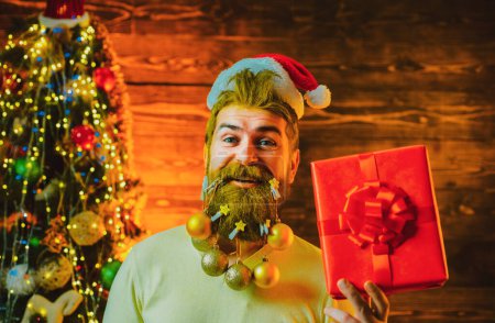 Foto de Regalos de entrega. Año Nuevo, tarjeta de Navidad. Hipster Papá Noel moderno desea Feliz Navidad. Estilo Santa Claus con una larga barba posando sobre el fondo de madera - Imagen libre de derechos