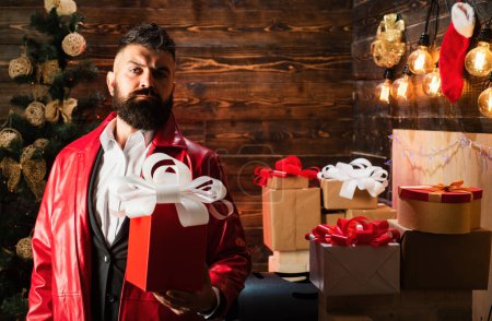 Photo for Hipster santa claus. New year gift box. Bearded modern santa wishes Merry christmas and Happy new year - Royalty Free Image