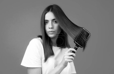 Photo for Woman brushing hair with comb. Beautiful girl combing long hair with hairbrush - Royalty Free Image