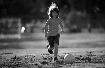 Foto de Niño jugando al fútbol en el campo de fútbol. Un chico jugando al fútbol. Infancia y deporte. Pequeño campeón de fútbol - Imagen libre de derechos