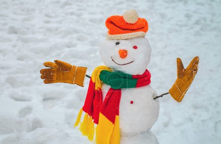 Foto de Día de muñeco de nieve y nieve. Muñeco de nieve con bufanda y sombrero. Saludo muñeco de nieve. Feliz Navidad y Felices Fiestas. Hombre de nieve en el bosque de nieve. - Imagen libre de derechos