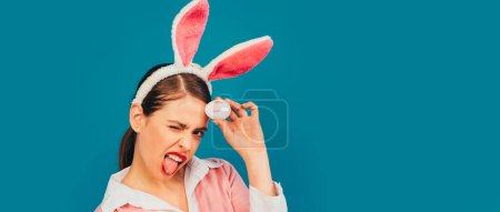 Foto de Banner de Pascua con mujer conejita. Mujer joven con orejas de conejo. Retrato de una mujer feliz con orejas de conejo. Caza de huevos. Labios y Pascua, impresión de beso de lápiz labial en huevo de Pascua - Imagen libre de derechos