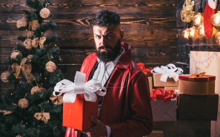 Foto de Bearded santa moderna desea Feliz Navidad y Feliz año nuevo. Caja de regalo de año nuevo. Santa Claus con regalos de Navidad - Imagen libre de derechos