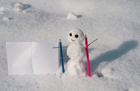 Foto de Snow man in winter day. Content writer. Blog creation concept with snowman, freelance work business and marketing. Creative online blog image with pencil and empty paper blank - Imagen libre de derechos