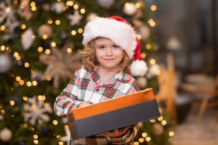 Foto de Niño en sombrero rojo Santa celebración de regalo de Navidad. Concepto de Navidad y Año Nuevo - Imagen libre de derechos
