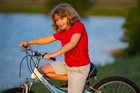Téléchargez les photos : Enfant à vélo. Petit garçon caucasien mignon à vélo dans le parc de la ville. Enfant premier vélo. Enfants en plein air activités estivales. Enfant à vélo. Garçon monter un vélo - en image libre de droit