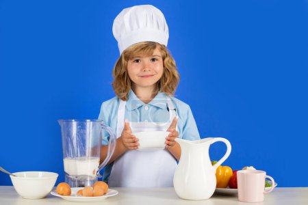 Photo for Cooking children. Chef kid boy making fresh vegetables for healthy eat. Portrait of little child in form of cook isolated on blue background. Kid chef. Cooking process - Royalty Free Image