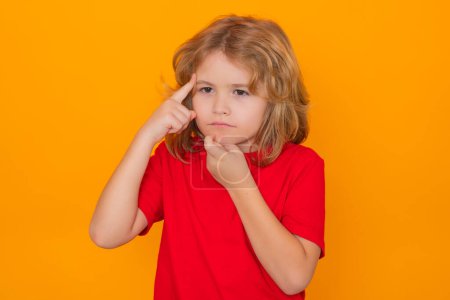 Photo for Kid have idea on yellow isolated background. Child pointing up fingerand thinking, on yellow background. Little thinker - Royalty Free Image