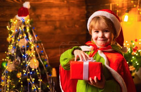 Téléchargez les photos : Maison remplie de joie et d'amour. Joyeux Noël et bonne année. Fête de la famille Noël. Cadeaux et surprises. Mignon petit garçon enfant jouer près de l'arbre de Noël. Enfant profiter des vacances d'hiver à la maison. - en image libre de droit