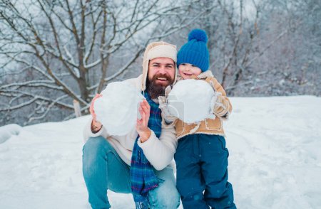 Photo for Happy father and son making snowman in the snow. Handmade funny snow man - Royalty Free Image
