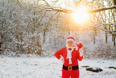 Téléchargez les photos : Santa venir à la forêt d'hiver avec un sac de cadeaux, paysage de neige - en image libre de droit