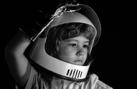 Photo for Child boy imagines himself to be an astronaut in an space helmet. Close up kids portrait isolated on black, adventure imagination - Royalty Free Image