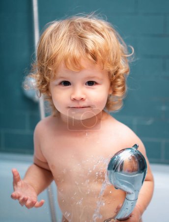 Foto de Ducha para niños. Lindo bebé niño disfrutando de baño y bañado en el baño - Imagen libre de derechos