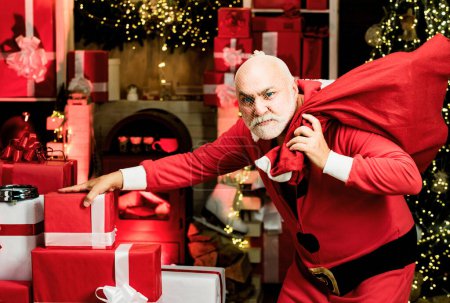 Foto de Ladrón robó regalos de año nuevo. Navidad criminal. Criminal Santa Claus posando con una bolsa de regalos de Navidad - Imagen libre de derechos