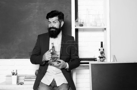 Foto de Portrait of teacher man hold microscope at school in classroom at school - Imagen libre de derechos