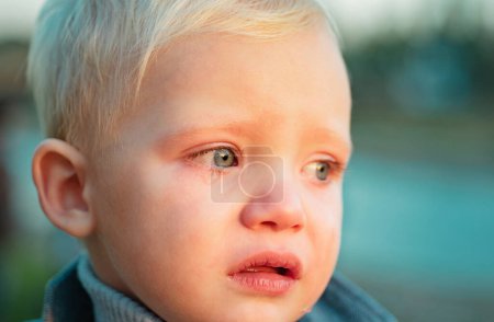 Foto de Niño con lágrimas cerca de fondo desenfocado. Bebé triste emocional. Cara triste niño llorando. Emociones tristes. Es difícil ser un niño pequeño. Lindo hijo llorando cara. Razones por las que bebé llora. Lágrimas en los ojos
. - Imagen libre de derechos