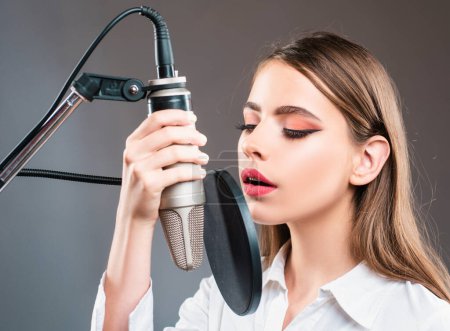 Photo for Young woman with microphone singing song. Musician in music hall. Funny teen singing in karaoke - Royalty Free Image