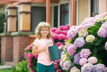 Téléchargez les photos : Des plantes d'eaux pour enfants dans le jardin arrière-cour avec arrosoir - en image libre de droit