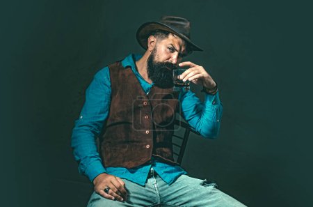 Photo for Stylish elegant bearded man Bartender holds whiskey glass. Luxury beverage concept. Fashionable man in white shirt and suspenders - Royalty Free Image