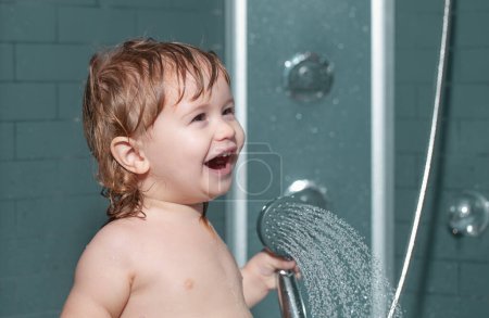 Téléchargez les photos : Enfant se baignant sous une douche. Petit bébé enfant se lave les cheveux dans le bain - en image libre de droit