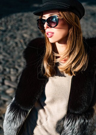 Photo for Eyewear trend. Pretty woman in hat and sunglasses and furry vest urban background. Fall fashion accessory. Enjoy fall season. Woman enjoy sunny day outdoors. Fall outfit. Modern casual outfit. - Royalty Free Image