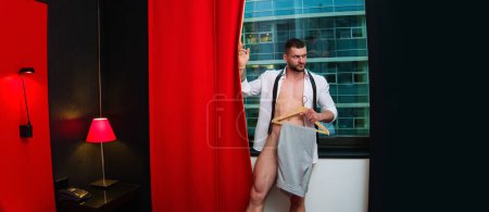 Téléchargez les photos : Sexy jeune homme nu dans le salon sur les rideaux de fenêtre. Corps masculin nu. Modèle sexy. Jeune homme musclé au corps sexy. La poitrine nue. Torse masculin musculaire, épaules nues - en image libre de droit