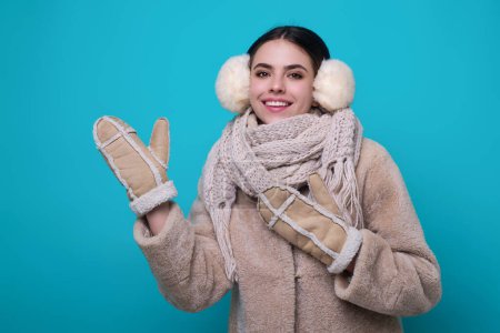 Photo for Woman in winter warm hat. Portrait of happy girl in woolen woolen clothes on blue studio background. Girl in winter cloth. Young woman in winter coat knitted sweater scarf and hat. Winter cold season - Royalty Free Image