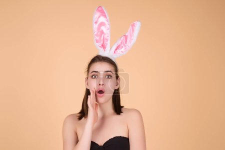 Téléchargez les photos : Femme avec des oreilles de lapin et des œufs de Pâques. Lapin de Pâques isolé sur fond de studio. Vacances, printemps et concept de fête. Portrait d'une jolie fille joyeuse aux oreilles de lapin célébrant Pâques - en image libre de droit