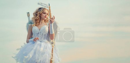 Photo for Lovely child. little Cupid girl aiming at someone with an arrow of love. Bow and arrow. Banner. Angel teenager girl with white wings - Royalty Free Image