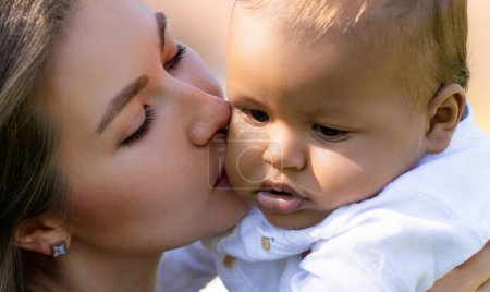 Téléchargez les photos : Gros plan portrait de mère embrassant bébé multiracial. Maman embrasse Biracial enfant. Gros plan de mère avec bébé Biracial embrasser en plein air. Des mères tendres s'embrassent. Biracial ou multiracial bébé et maman embrassé - en image libre de droit