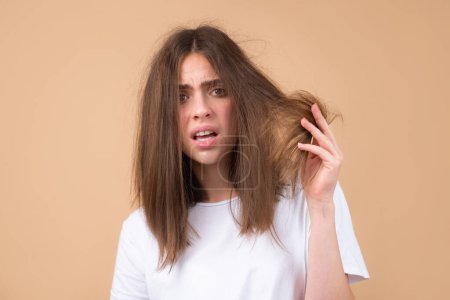 Photo for Sad stressed woman with straight brushed hair. Hair tangling problem. Unhappy girl with tangled hair. Damaged hair combing - Royalty Free Image