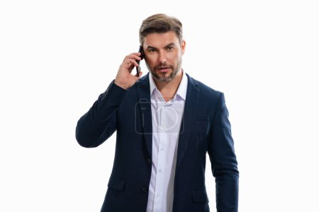 Foto de Hombre de negocios guapo en traje usando teléfono inteligente, charlando, haciendo post en las redes sociales. Un hombre de negocios llama por teléfono aislado en el fondo del estudio. Blogger hablando por teléfono - Imagen libre de derechos