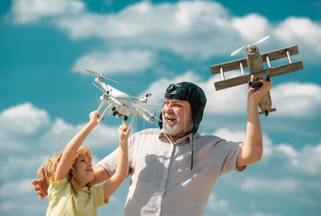 Photo for Grandfather and son with plane and quad copter drone over blue sky. Men generation granddad and grandchild. Elderly old relative with child - Royalty Free Image