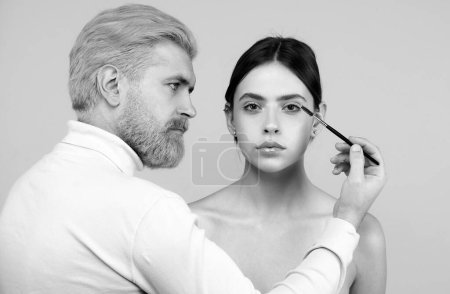 Photo for Beautiful woman with long eyelashes, eyebrows. Makeup and cosmetology concept. Professional man visagiste make up artist combing brows for beauty women - Royalty Free Image