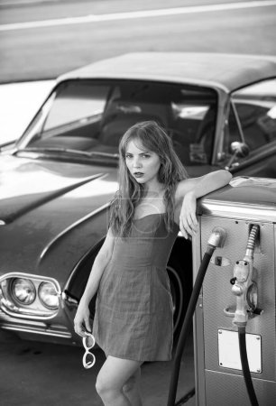 Photo for Red retro automobile. Old American Car. Gas station girl. Woman refuel the auto - Royalty Free Image