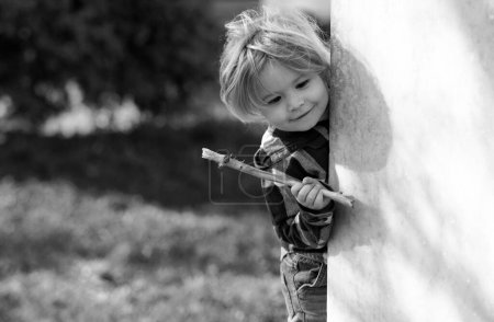Photo for Little child play in park. Outdoor cute little boy playing hide and seek. Adorable child having fun in the park. Childhood - Royalty Free Image