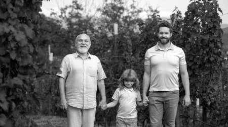 Téléchargez les photos : Trois générations d'hommes caucasiens. Enfant garçon avec père et vieux grand-père. Exploitations agricoles et jardinage à la ferme à la campagne - en image libre de droit