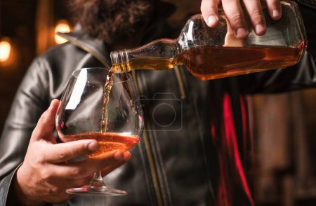 Foto de Un hombre guapo sosteniendo un vaso de whisky. Bebiendo whisky. Degustación, degustación. Hombre sosteniendo un vaso de whisky - Imagen libre de derechos