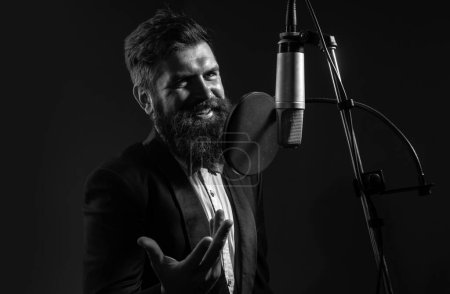 Photo for Classical music. Singing man in a recording studio. Expressive bearded man with microphone. Karaoke signer, musical vocalist - Royalty Free Image