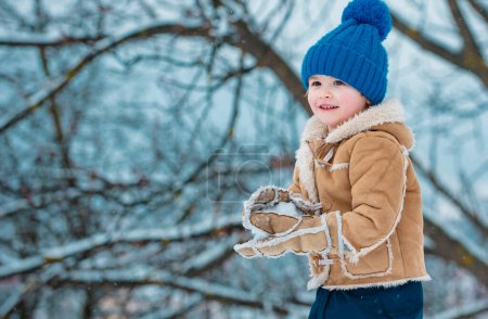 Photo for Theme Christmas holidays New Year. Winter snow and child game. Happy winter time for kid. Joyful little boy child Having Fun in Winter Park - Royalty Free Image