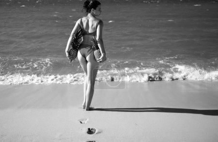 Foto de Mujer con nalgas sexy en traje de baño. Mujer joven sosteniendo una piña en la playa dominicana o hawaii. Vacaciones de verano en la playa - Imagen libre de derechos