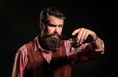 Foto de Elegante y elegante hombre en el clásico vidrio de celebración de desgaste con whisky en la mano - Imagen libre de derechos