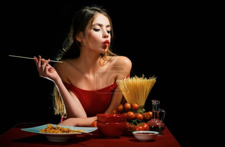 Téléchargez les photos : Une femme sensuelle mange des spaghettis. Concept d'alimentation saine. Faim et appétit. Fille surprise avec des nouilles spaghetti. Pâtes longues macaroni - en image libre de droit