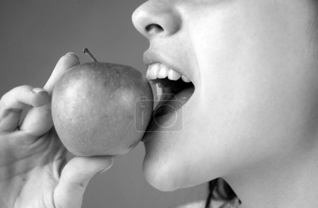Foto de Una hembra mordiendo una manzana. Mujer boca abierta a punto de morder manzana verde - Imagen libre de derechos