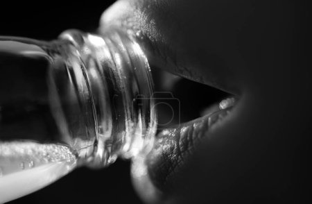 Téléchargez les photos : Femme bouche l'eau potable de la bouteille. Fermez l'eau potable. Lèvres sensuelles - en image libre de droit
