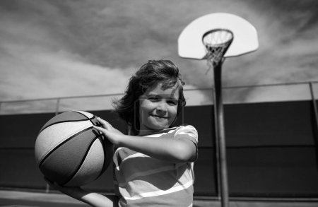 Foto de Niño jugando baloncesto con pelota de baloncesto. Retrato de niño deportivo - Imagen libre de derechos