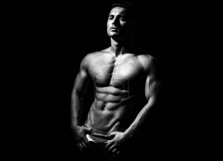 Foto de Sexy torso desnudo masculino. Hombre fuerte, en forma y deportivo sobre fondo negro - Imagen libre de derechos